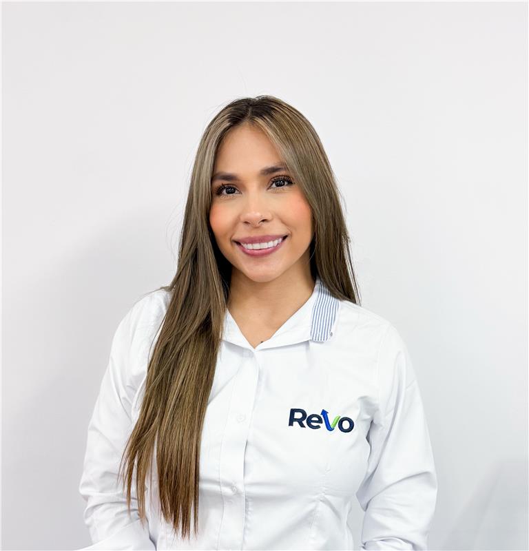 A woman with long brown hair wearing a white shirt with the 'Revo' logo standing against a plain white background, smiling at the camera.