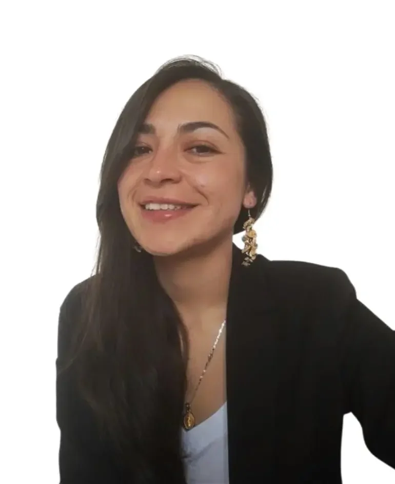 A woman with long dark hair smiling and wearing a black blazer, a white top, and decorative earrings, against a plain white background.