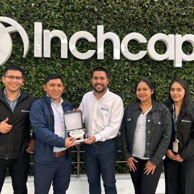 Five people standing in front of a green leafy wall with the Inchcape logo, holding an award.
